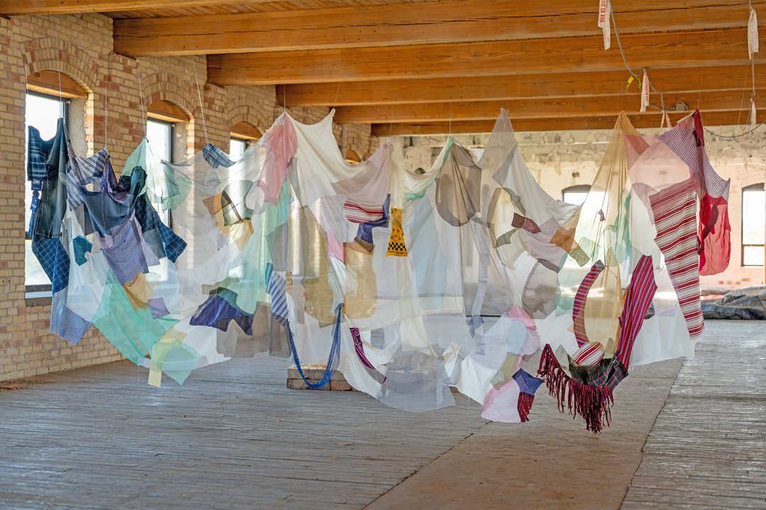 Installation show of a delicate, draping, and multi-pieced work of textile art by Ami Park
